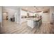 Spacious kitchen with wood-style flooring, modern appliances, granite counters, and large kitchen island at 2198 Maderno St, Henderson, NV 89044
