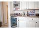 Close-up of wet bar with beverage fridge, granite countertops, and custom cabinets at 2198 Maderno St, Henderson, NV 89044