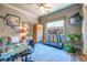 Bright bedroom features a ceiling fan, treadmill, wall-mounted TV, and comfortable seating area, perfect for relaxation and exercise at 2539 Turtle Head Peak Dr, Las Vegas, NV 89135