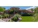 This beautiful home has a well-manicured lawn with lush trees, desert plants and exterior lighting at 2539 Turtle Head Peak Dr, Las Vegas, NV 89135