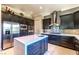 Modern kitchen featuring stainless steel appliances, dark cabinets, and a large island at 2539 Turtle Head Peak Dr, Las Vegas, NV 89135