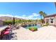 Stunning backyard pool featuring a bar with seating, palm trees, and beautiful desert views at 2539 Turtle Head Peak Dr, Las Vegas, NV 89135