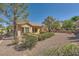 A well-manicured backyard featuring a gravel yard, mature trees, and a covered patio at 2601 Deer Lake St, Las Vegas, NV 89134