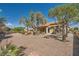 Backyard featuring decorative gravel landscaping, mature trees, and a covered patio at 2601 Deer Lake St, Las Vegas, NV 89134