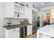 Bright kitchen featuring white cabinetry, stainless steel appliances, beverage fridge, and a stylish backsplash at 2710 Marchetti Pl, Henderson, NV 89044