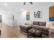 Bright living room with plush sectional sofa, wood floors, and stylish decor with natural lighting at 2710 Marchetti Pl, Henderson, NV 89044