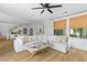 Bright living room with white sectional, stylish decor, and wood-look flooring at 2710 Marchetti Pl, Henderson, NV 89044