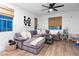 Bright living room with plush sectional sofa, wood floors, and ceiling fan for added comfort at 2710 Marchetti Pl, Henderson, NV 89044