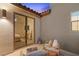 Cozy outdoor patio space with seating and view into the bedroom through a sliding glass door at 2710 Marchetti Pl, Henderson, NV 89044