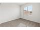 A bright bedroom with gray carpet, white walls and large window at 2733 Avril Point St, Las Vegas, NV 89156
