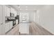 Bright kitchen featuring an island, stainless steel appliances, white cabinetry, and wood-look flooring at 2739 Avril Point St, Las Vegas, NV 89156