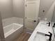 Stylish bathroom featuring double sinks with quartz countertops, a soaking tub, and modern fixtures at 3240 Lahontan St, North Las Vegas, NV 89032