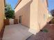 View of a concrete backyard and stucco exterior with sliding glass door and rock landscaping on a sunny day at 3311 Fico Ave, Las Vegas, NV 89141