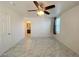 Bedroom with neutral walls, ceiling fan, tile flooring, and bathroom access at 3311 Fico Ave, Las Vegas, NV 89141