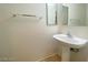 Powder room with pedestal sink, square mirror, and neutral walls at 3311 Fico Ave, Las Vegas, NV 89141