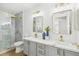 Bright bathroom with double sinks, updated lighting, and glass enclosed shower with tile surround at 3425 E Russell Rd # 202, Las Vegas, NV 89120