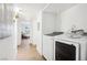 Bright and modern laundry room with washer and dryer, with hallway leading to furnished space at 3425 E Russell Rd # 202, Las Vegas, NV 89120