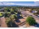 Expansive property featuring a fenced paddock, lush trees, and stunning city views in the distance at 3455 Five Pennies Ln, Las Vegas, NV 89120
