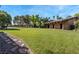 Expansive lawn with mature trees, a covered patio and pathways in the backyard of this property at 3455 Five Pennies Ln, Las Vegas, NV 89120