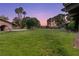 Expansive backyard featuring a well-maintained lawn, mature trees, and an outdoor brick structure at 3455 Five Pennies Ln, Las Vegas, NV 89120