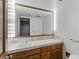 Bright bathroom featuring a vanity with a tiled countertop, integrated sink, and a large, well-lit mirror at 3455 Five Pennies Ln, Las Vegas, NV 89120