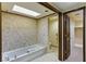 Bathroom featuring a tub, a glass shower and a doorway to closet and toilet at 3455 Five Pennies Ln, Las Vegas, NV 89120