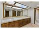 Bathroom with a long vanity featuring double sinks, tiled countertop, and a large mirror at 3455 Five Pennies Ln, Las Vegas, NV 89120