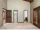 Bright bedroom featuring doors to outside, access to other rooms, and brick walls at 3455 Five Pennies Ln, Las Vegas, NV 89120