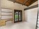 Bedroom featuring exposed beam ceiling, brick walls, built-in desk, and French doors to backyard at 3455 Five Pennies Ln, Las Vegas, NV 89120