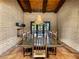 Formal dining room with a long wooden table, seating for ten, brick walls, fireplace and backyard view at 3455 Five Pennies Ln, Las Vegas, NV 89120