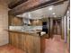 View of kitchen with counter bar, brick walls, wood cabinets and terracotta floors at 3455 Five Pennies Ln, Las Vegas, NV 89120