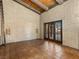 Spacious living room with brick walls, tiled floors, wood beams and double glass door to the yard at 3455 Five Pennies Ln, Las Vegas, NV 89120