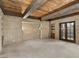 Inviting living room with exposed wood beams, brick walls, plush carpeting, and outdoor access at 3455 Five Pennies Ln, Las Vegas, NV 89120