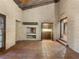 Spacious living room features brick walls, beamed ceiling, and view to kitchen area at 3455 Five Pennies Ln, Las Vegas, NV 89120