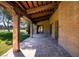 Covered patio featuring brick walls, wooden beams, and view of yard at 3455 Five Pennies Ln, Las Vegas, NV 89120