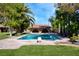 An inviting swimming pool with a diving board surrounded by a well-manicured lawn and mature trees at 3455 Five Pennies Ln, Las Vegas, NV 89120