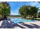 An inviting swimming pool and mature trees create a tranquil backyard setting with a tennis court in the background at 3455 Five Pennies Ln, Las Vegas, NV 89120
