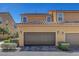 Townhouse exterior with a two-car garage and desert landscaping in a vibrant neighborhood at 3514 Punta Tersiva Ln, Henderson, NV 89044
