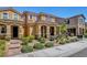 Exterior view of tan homes featuring tidy landscaping, covered entryways and attractive facades at 3514 Punta Tersiva Ln, Henderson, NV 89044