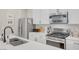 Modern kitchen with stainless steel appliances, stylish white countertops, and ample storage at 3514 Punta Tersiva Ln, Henderson, NV 89044