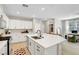 Bright kitchen with white cabinets, an island, and seamless flow to the office space at 3514 Punta Tersiva Ln, Henderson, NV 89044