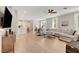 Open-concept living room with light hardwood floors, modern furnishings, and abundant natural light at 3514 Punta Tersiva Ln, Henderson, NV 89044