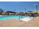 Community pool with lounge chairs, blue umbrellas, and handicap access at 3514 Punta Tersiva Ln, Henderson, NV 89044
