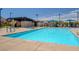 Community pool with lounge chairs and a covered seating area at 3514 Punta Tersiva Ln, Henderson, NV 89044