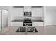 Stylish kitchen featuring stainless steel appliances, a gray countertop, and sleek white cabinets at 4219 Gold Desert St, North Las Vegas, NV 89032