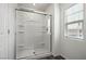 Bathroom featuring a glass-enclosed shower with built-in shelves and a window with blinds at 4223 Gold Desert St, North Las Vegas, NV 89032