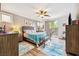 Comfortable bedroom with wood-look floors, ceiling fan, and view of the backyard at 4317 Via Vinci Ct, Pahrump, NV 89061