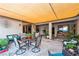 Relaxing covered patio featuring cozy seating, plants, and tiled flooring for outdoor enjoyment at 4317 Via Vinci Ct, Pahrump, NV 89061