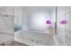 Close-up of a luxurious bathtub with jacuzzi jets and sleek marble tile surround at 4381 W Flamingo Rd # 5318, Las Vegas, NV 89103