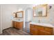 Bright bathroom with double vanities and elegant fixtures with a view into the hallway at 4412 Red Blanket Rd, North Las Vegas, NV 89032